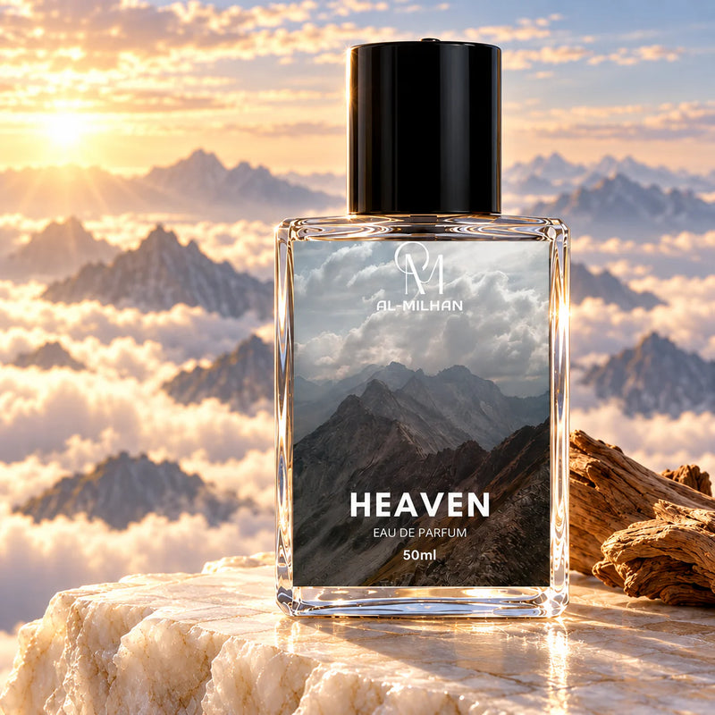 Heaven clear perfume bottle on a pale stone ledge above sunlit clouds, with distant mountains and a wood fragment.