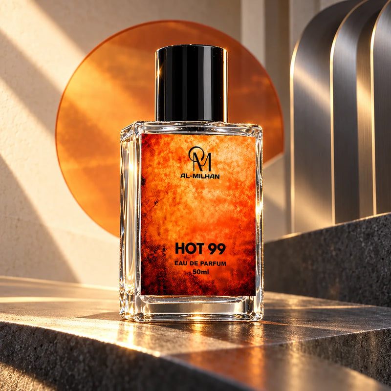 Hot 99 clear perfume bottle with its orange label on dark stone before a burnt-orange sun disc and brushed-metal architecture.