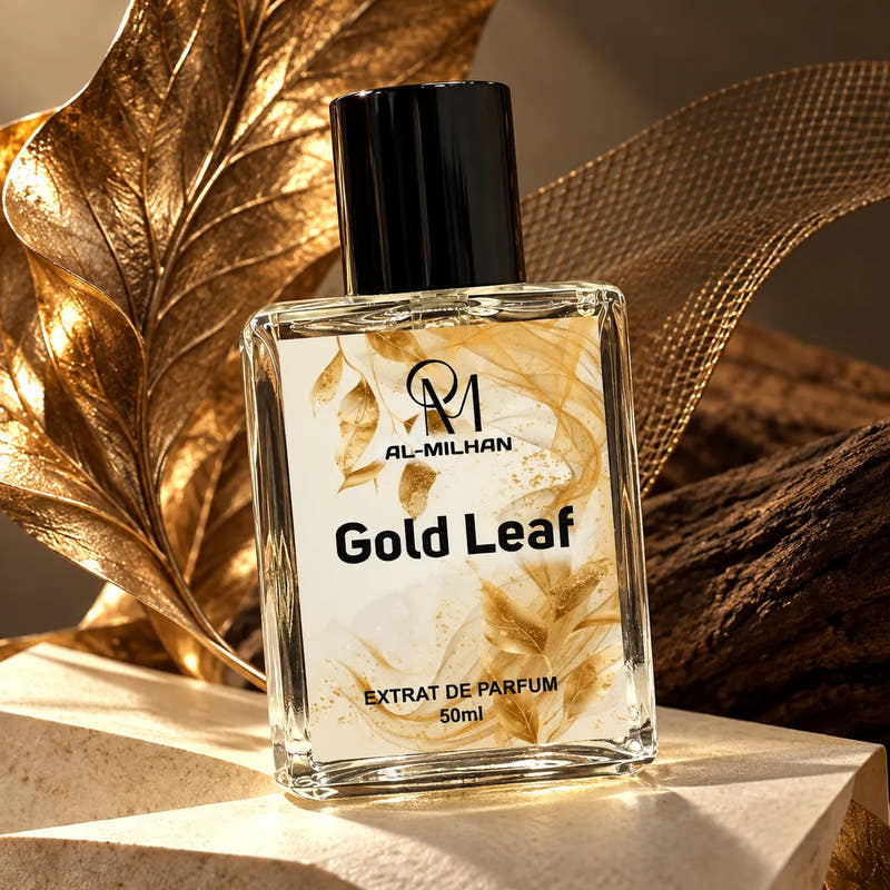 Gold Leaf perfume bottle by Al Milhan with clear liquid and its gold leaf label beside bronze leaf sculpture and ivory stone.